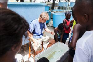 an Bouyoucos, M.Sc candidate at the University of Illinois, prepares to show the students a juvenile lemon shark.